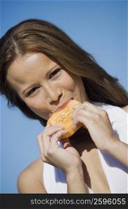 Portrait of a young woman eating a slice of melon