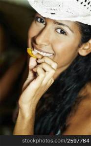 Portrait of a young woman eating a wafer