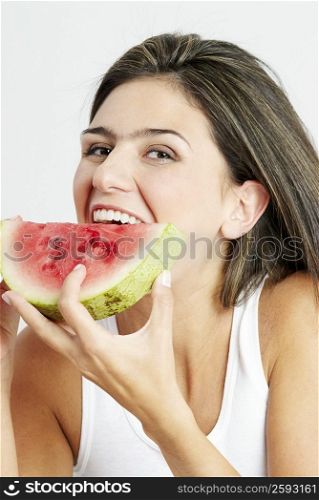 Portrait of a young woman eating a watermelon