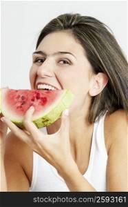 Portrait of a young woman eating a watermelon