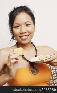 Portrait of a young woman eating biscuits