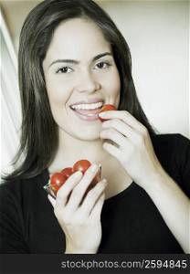 Portrait of a young woman eating plums