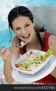 Portrait of a young woman eating salad