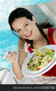 Portrait of a young woman eating salad