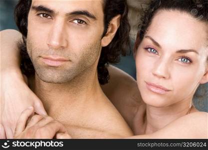Portrait of a young woman embracing a mid adult man from behind
