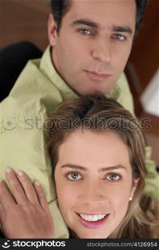 Portrait of a young woman embracing a young man