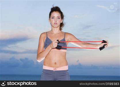 Portrait of a young woman exercising with a resistance band