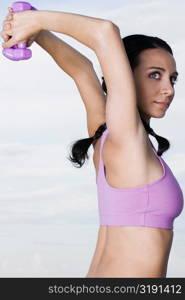 Portrait of a young woman exercising with dumbbells