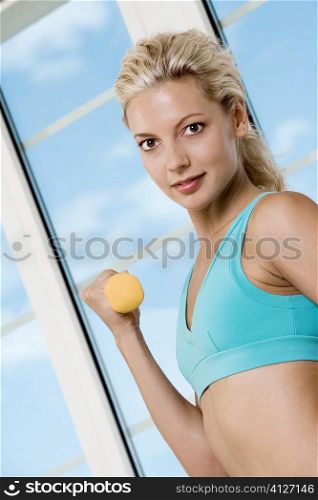 Portrait of a young woman exercising with dumbbells