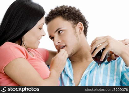 Portrait of a young woman feeding grapes to a young man