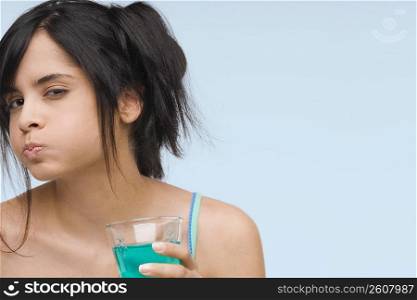 Portrait of a young woman gargling