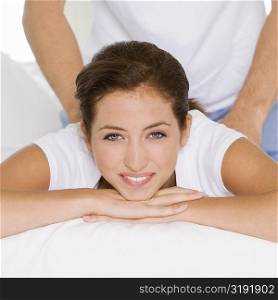 Portrait of a young woman getting a back massage from a young man