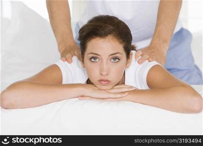 Portrait of a young woman getting a back massage from a young man