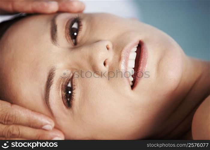 Portrait of a young woman getting a head massage