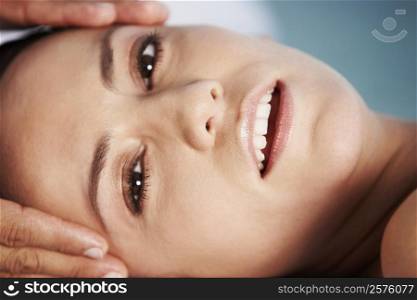 Portrait of a young woman getting a head massage
