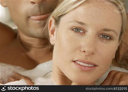 Portrait of a young woman getting a massage form a young man in a bubble bath