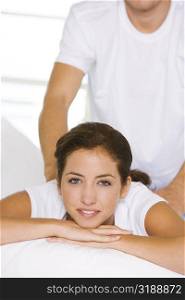 Portrait of a young woman getting a shoulder massage