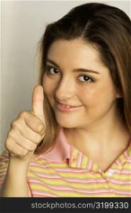 Portrait of a young woman giving a thumbs up gesture
