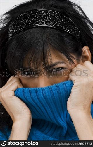 Portrait of a young woman hiding her face in her dress