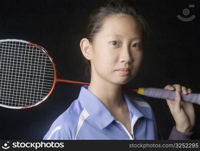Portrait of a young woman holding a badminton racket