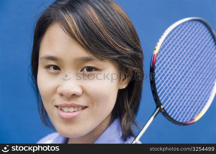 Portrait of a young woman holding a badminton racket