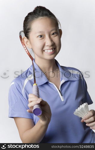 Portrait of a young woman holding a badminton racket and a shuttlecock