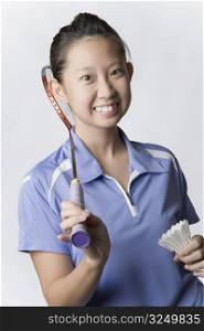 Portrait of a young woman holding a badminton racket and a shuttlecock