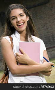 Portrait of a young woman holding a book and smiling