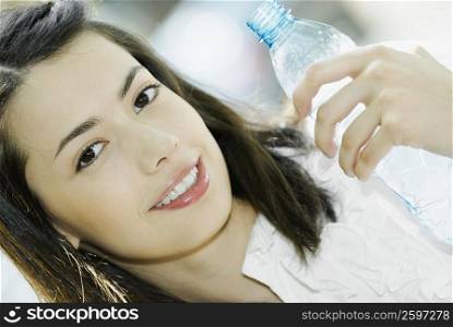 Portrait of a young woman holding a bottle of water