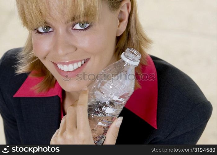 Portrait of a young woman holding a bottle of water