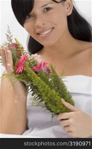 Portrait of a young woman holding a bouquet and smiling