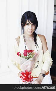 Portrait of a young woman holding a bouquet of flowers