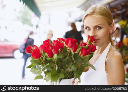 Portrait of a young woman holding a bouquet of flowers