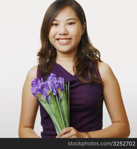 Portrait of a young woman holding a bouquet of flowers