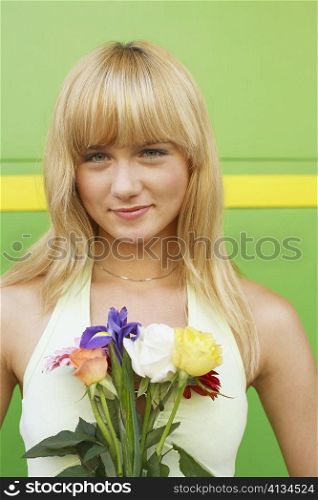 Portrait of a young woman holding a bouquet of flowers