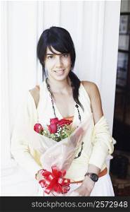 Portrait of a young woman holding a bouquet of flowers and smiling