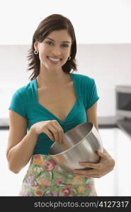Portrait of a young woman holding a bowl and smiling