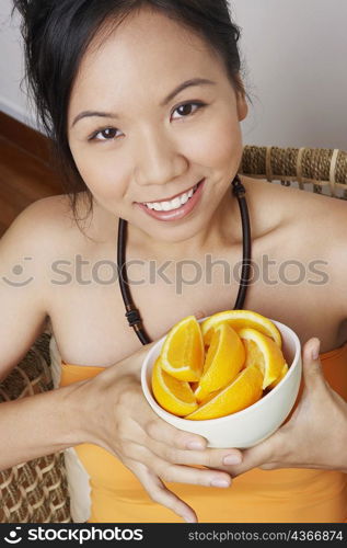 Portrait of a young woman holding a bowl and smiling