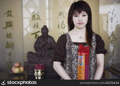 Portrait of a young woman holding a box of incense sticks