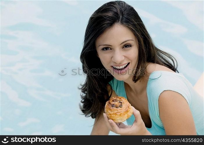 Portrait of a young woman holding a bun