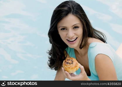 Portrait of a young woman holding a bun