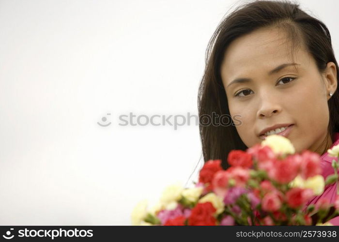 Portrait of a young woman holding a bunch of flowers