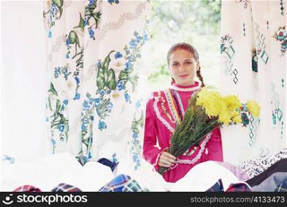 Portrait of a young woman holding a bunch of flowers