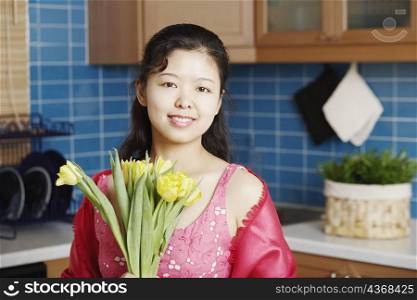 Portrait of a young woman holding a bunch of flowers smiling