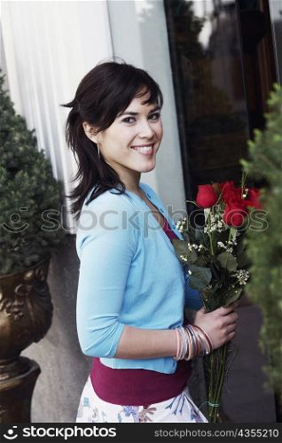 Portrait of a young woman holding a bunch of roses