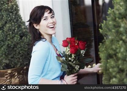 Portrait of a young woman holding a bunch of roses