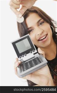 Portrait of a young woman holding a calculator and a coin