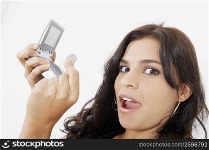 Portrait of a young woman holding a calculator and a coin