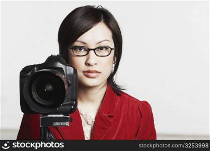 Portrait of a young woman holding a camera