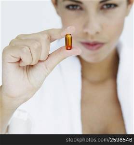 Portrait of a young woman holding a capsule